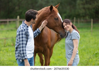 happy loving couple spending time with horses on ranch - Powered by Shutterstock