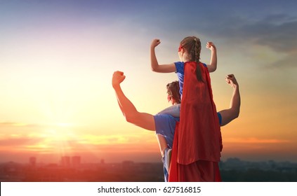Happy loving family. Dad and his daughter playing outdoors. Daddy and child girl in an Superhero's costumes. Concept of Father's day. - Shutterstock ID 627516815