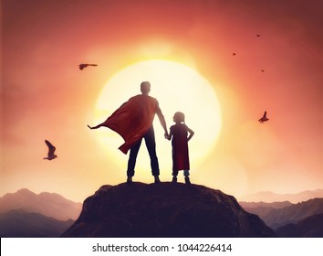 Happy loving family. Father and his daughter playing outdoors. Daddy and his child girl in an Superhero's costumes.