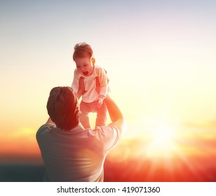 Happy Loving Family. Father And His Daughter Baby Girl Playing And Hugging Outdoors. Concept Of Father's Day.