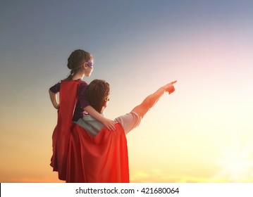 Happy loving family. Father and his daughter child girl playing outdoors. Daddy and his child girl in an Superhero's costumes. Concept of Father's day.