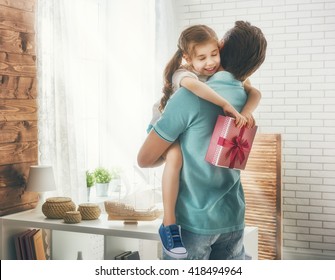 Happy Loving Family And Father's Day. Father And His Daughter. Cute Child Girl Gives A Gift To Dad.