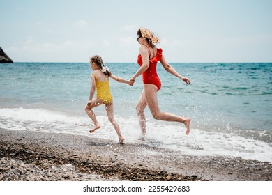 Happy loving family mother and daughter having fun together on the beach. Mum playing with her kid in holiday vacation next to the ocean - Family lifestyle and love concept - Shutterstock ID 2255429683