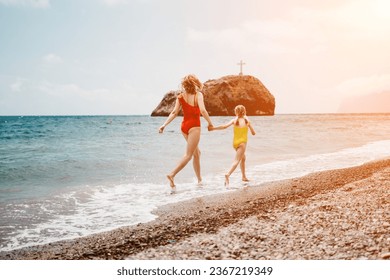 Happy loving family mother and daughter having fun together on the beach. Mum playing with her kid in holiday vacation next to the ocean - Family lifestyle and love concept - Shutterstock ID 2367219349