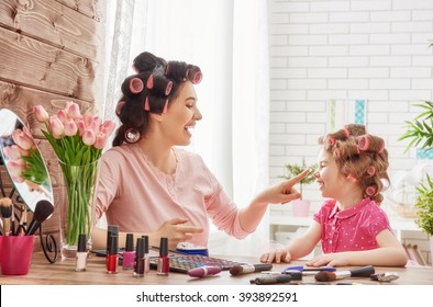 Happy loving family. Mother and daughter are doing hair, manicures, doing your makeup and having fun. Mother and daughter sitting at dressing table at house. - Powered by Shutterstock