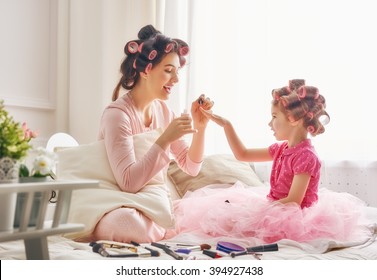 Happy loving family. Mother and daughter are doing hair, manicures and having fun. Mother and daughter sitting on the bed in the bedroom. - Powered by Shutterstock