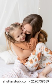 Happy Loving Family. Mother And Her Daughter Girl Play And Have Fun On The Bed In The Bedroom. The Pleasure Of Being A Mom, Mother's Day Greetings, The Concept Of A Sweet Moment Together