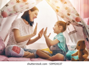 Happy Loving Family. Mother And Her Daughter Girl Play In Children Room. Funny Mom And Lovely Child Having Fun Indoors. 