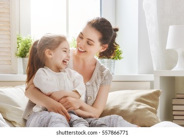 Happy loving family. Mother and her daughter child girl playing and hugging.