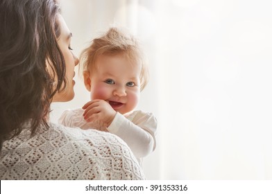 happy loving family. mother playing with her baby in the bedroom.