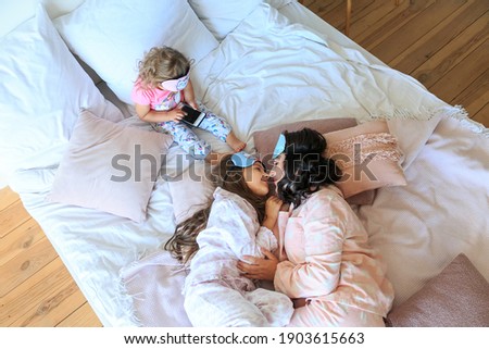 Similar – Relaxed mother and sons playing over the bed