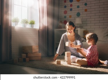 Happy Loving Family Playing With Blocks And Having Fun. Mother And Her Child Daughter Girl Playing Together.
