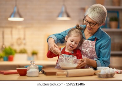 Happy loving family are preparing bakery together. Granny and child are cooking cookies and having fun in the kitchen. Homemade food and little helper. - Powered by Shutterstock