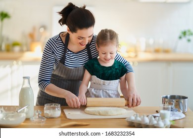 Happy Loving Family Are Preparing Bakery Together. Mother And Child Daughter Girl Are Cooking Cookies And Having Fun In The Kitchen. Homemade Food And Little Helper.                                