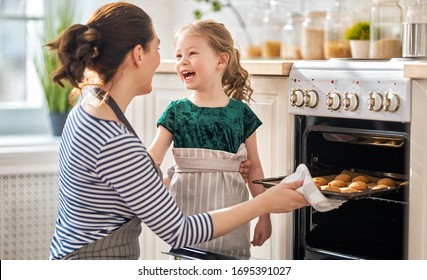 Happy loving family are preparing bakery together. Mother and child daughter girl are cooking cookies and having fun in the kitchen. Homemade food and little helper.                                 - Powered by Shutterstock