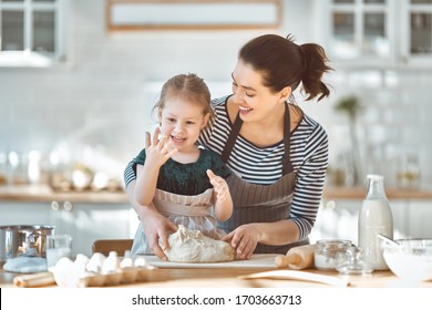 Happy Loving Family Are Preparing Bakery Together. Mother And Child Daughter Girl Are Cooking Cookies And Having Fun In The Kitchen. Homemade Food And Little Helper.                                  