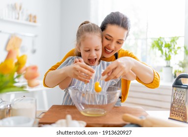 Happy loving family are preparing bakery together. Mother and child daughter girl are cooking cookies and having fun in the kitchen. Homemade food and little helper.      - Powered by Shutterstock