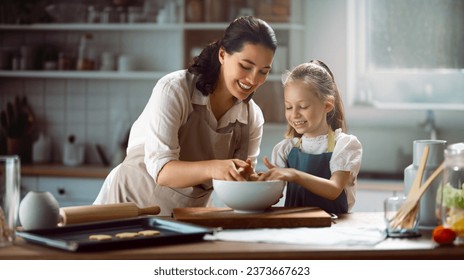 Happy loving family are preparing bakery together. Mother and child daughter girl are cooking cookies and having fun in the kitchen. Homemade food and little helper.  - Powered by Shutterstock