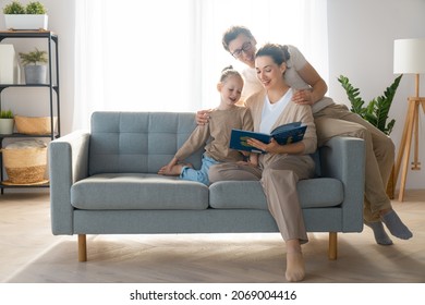 Happy loving family. Pretty young mother reading a book to her daughter. 