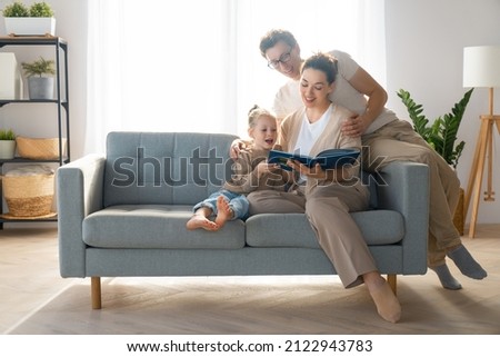 Happy loving family. Pretty young mother reading a book to her daughter.  