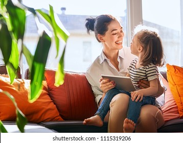 Happy Loving Family. Young Mother And Her Daughter Girl Play In Kids Room. Funny Mom And Lovely Child Are Having Fun With Tablet.