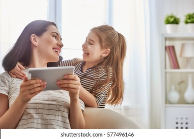 Happy Loving Family. Young Mother And Her Daughter Girl Play In Kids Room. Funny Mom And Lovely Child Are Having Fun With Tablet.