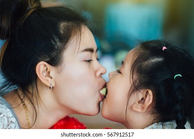 Happy loving family.Close-up Mother and child girl eating dessert from mouth