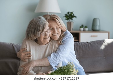 Happy loving mature daughter woman hugging old 80s mom with warmth, affection, devotion, visiting elderly mother, congratulating on birthday, 8 march day, enjoying family holiday - Powered by Shutterstock