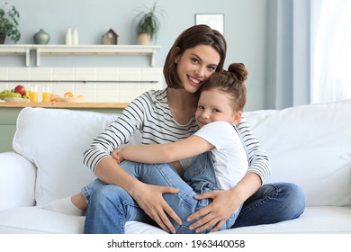 Happy loving mom hugging little daughter, spend time together at home.