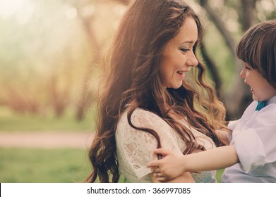 Happy Loving Mother With Toddler Son On The Walk In Sunny Park. Family Spending Time Together In Spring Or Summer. Cozy Warm Mood.