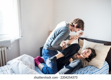 Happy Loving Young Couple Laughing Playing Childish In Bed At Home Tickling Having Fun