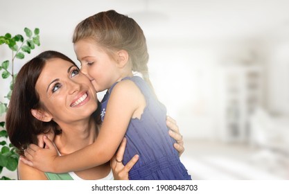 Happy loving young mother hugs little cute child at home.