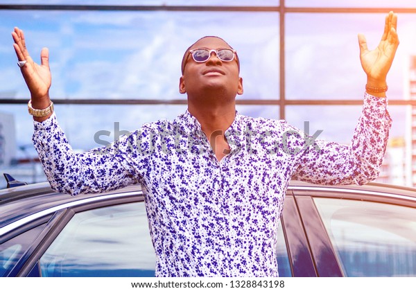 happy lucky and successful afro american\
businessman proud of himself and buying a cool car. concept of a\
good deal and victory