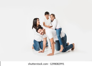 happy mad ride on father's back. Indian small girl sitting on Dad's back while mother and brother laughing. selective focus