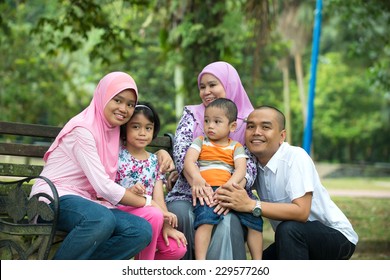 Happy Malay Asian Family Enjoying Family Time Together In The Park