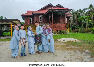  Happy Malay Family In Traditional Clothing And Traditional Malay House During Hari Raya. Malaysian Family Lifestyle At Home. Happiness Concept.