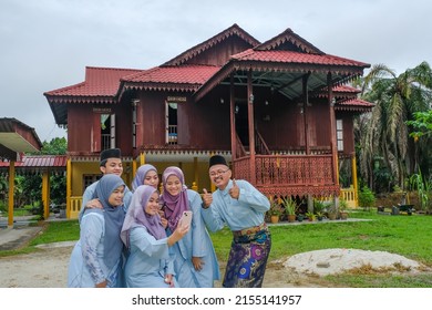 Happy Malay Family In Traditional Clothing And Traditional Malay House During Hari Raya. Malaysian Family Lifestyle At Home. Happiness Concept.