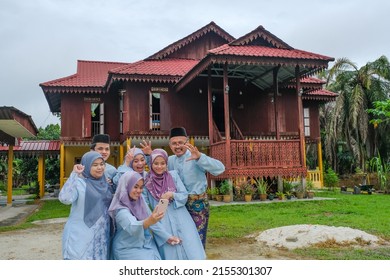 Happy Malay Family In Traditional Clothing And Traditional Malay House During Hari Raya. Malaysian Family Lifestyle At Home. Happiness Concept.