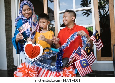 Happy Malaysian Family Decorate Bicycle With Flag For Independence Day Celebration. Malaysia Merdeka Basikal Hias