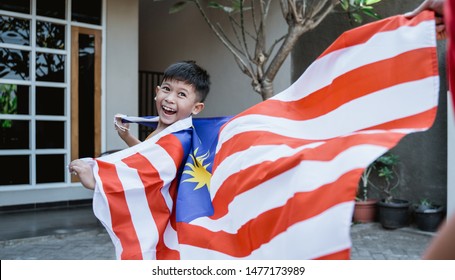 Happy Malaysian Kid Run Around The House Carrying Malaysia Flag