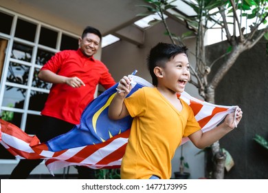 Happy Malaysian Kid Run Around The House Carrying Malaysia Flag