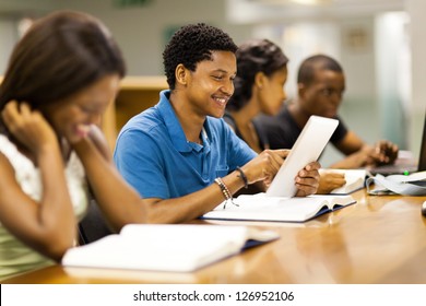 happy male african american college student using tablet computer