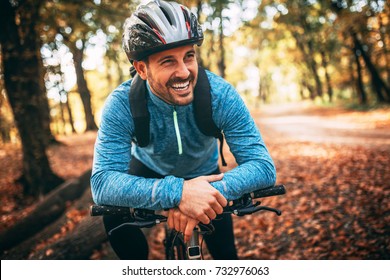 Felice ciclista maschio nella foresta.