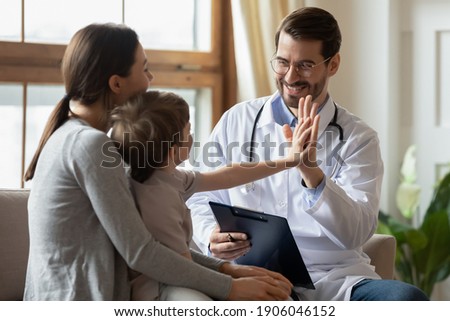 Happy male doctor have fun cheer support small 7s boy patient at visit to clinic with mom. Caring pediatrician give high five make deal with little child in hospital. Children healthcare concept. ストックフォト © 