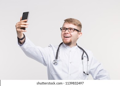 Happy Male Doctor Making Selfie In Studio