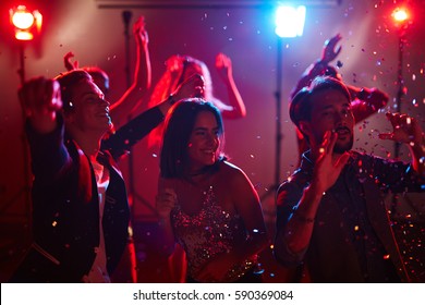 Happy Male And Female Students Dancing At Graduation Party With Loud Pop Music And Shining Confetti