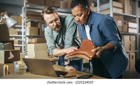 Happy Male And Female Working In Warehouse. Talking, Using Laptop Computer, Checking Retail Stock, Preparing Shipment With A Stylish Retro Bicycle Seat. Successful Storeroom Workers Enjoying Work.