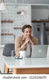 Happy male freelancer reading an e-mail on laptop at home office. - Shutterstock ID 2123236670