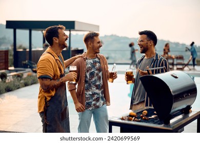 Happy male friends communicating while drinking beer during barbecue party by the pool.  - Powered by Shutterstock