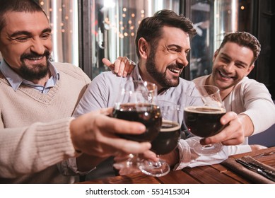 Happy Male Friends Raising Their Glasses